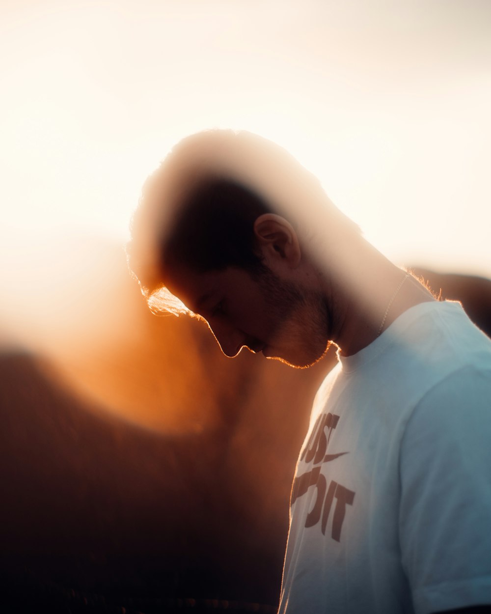 man in white crew neck shirt during sunset