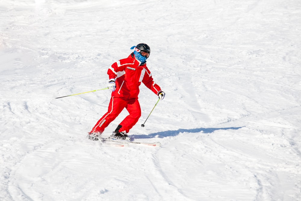 2 persone in giacca rossa e casco blu che cavalcano lame da sci su terreno innevato durante