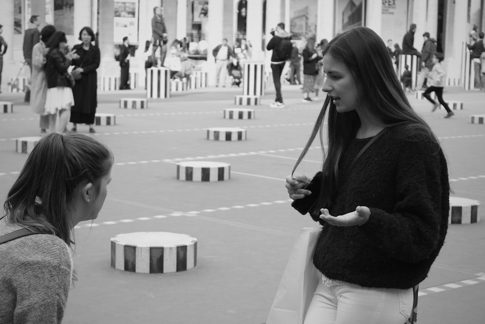 grayscale photo of girl in long sleeve shirt playing with bubbles