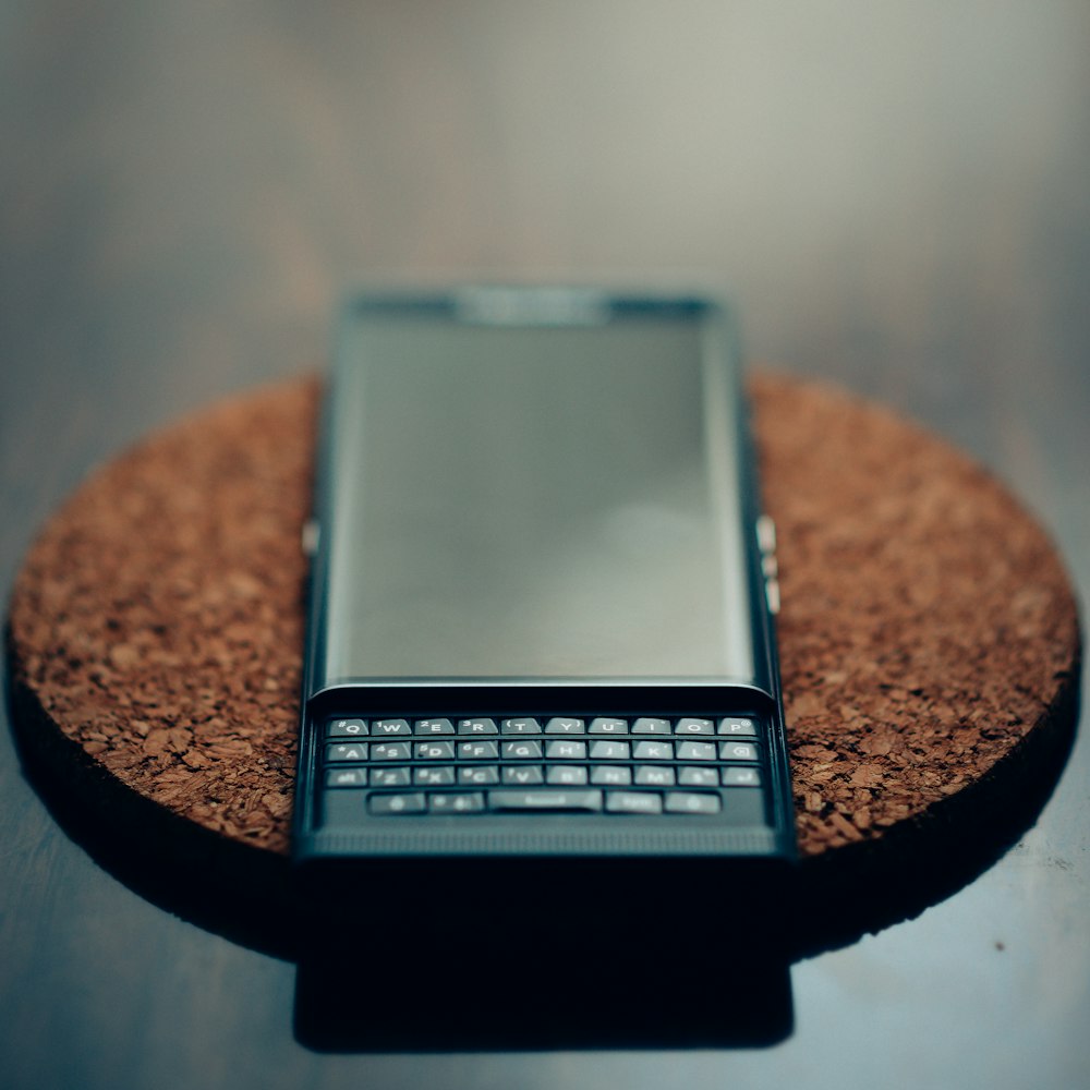 black and silver qwerty phone on brown round table