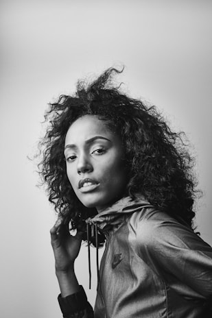 Black-and-white photo of a model wearing a sporty jacket with asymmetrical design.