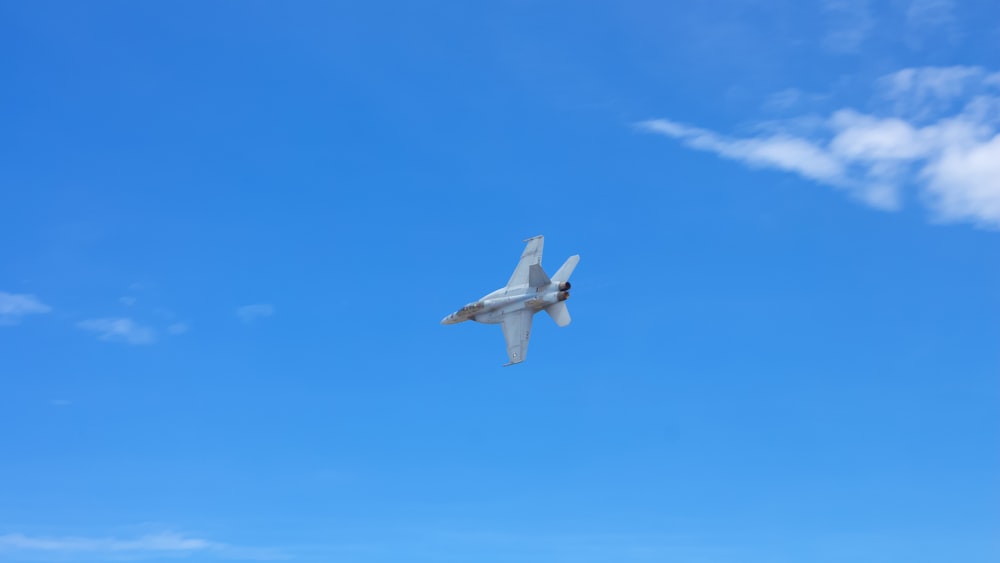 white jet plane flying in the sky during daytime