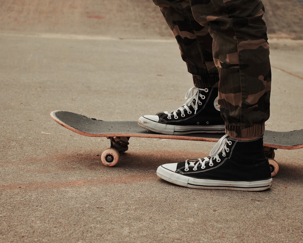 person in black and white nike sneakers riding skateboard during daytime