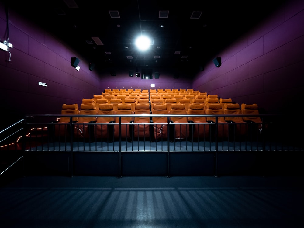 orange and white chairs with lights turned on in a stadium