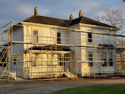 white wooden house near green grass field during daytime