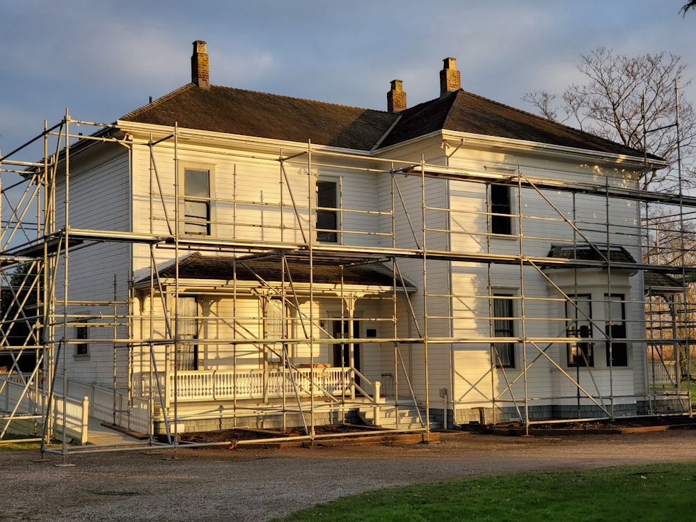 Weißes Holzhaus in der Nähe von grünem Grasfeld tagsüber