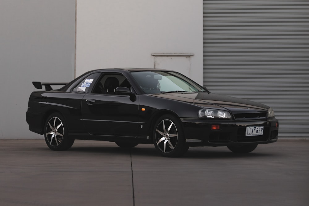 black bmw m 3 coupe parked near white wall