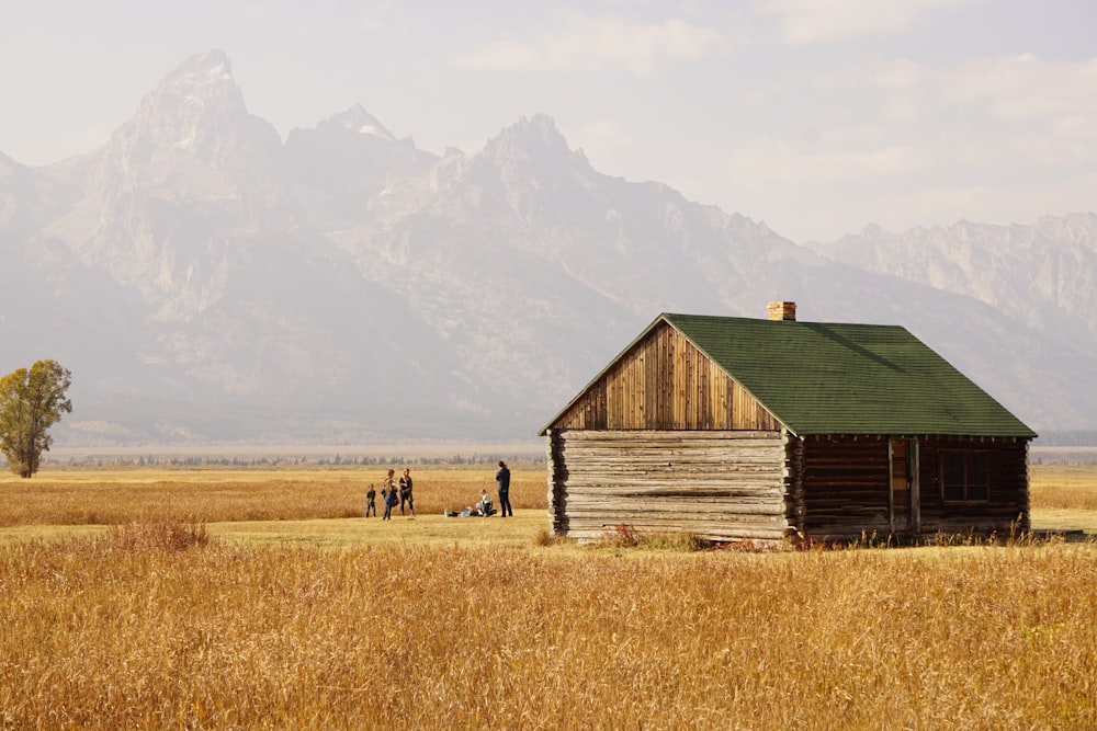 brown wooden barn in the middle of brown grass field