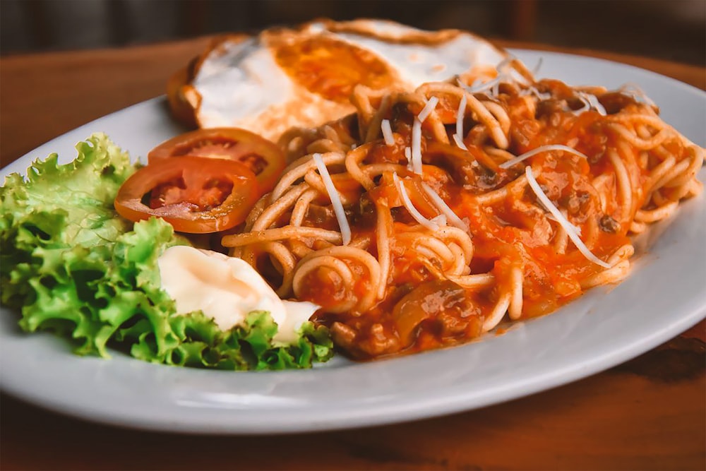 Pasta con salsa en plato de cerámica blanca