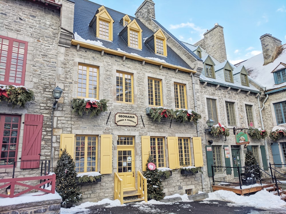 Bâtiment en béton brun avec des plantes vertes sur la fenêtre pendant la journée