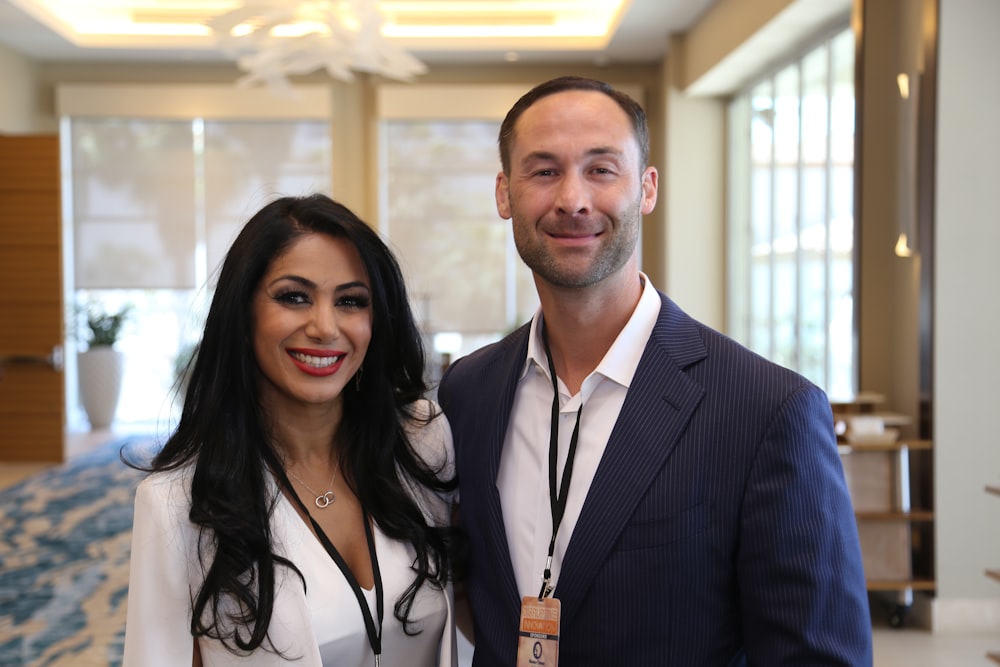 man in black suit jacket beside woman in white dress