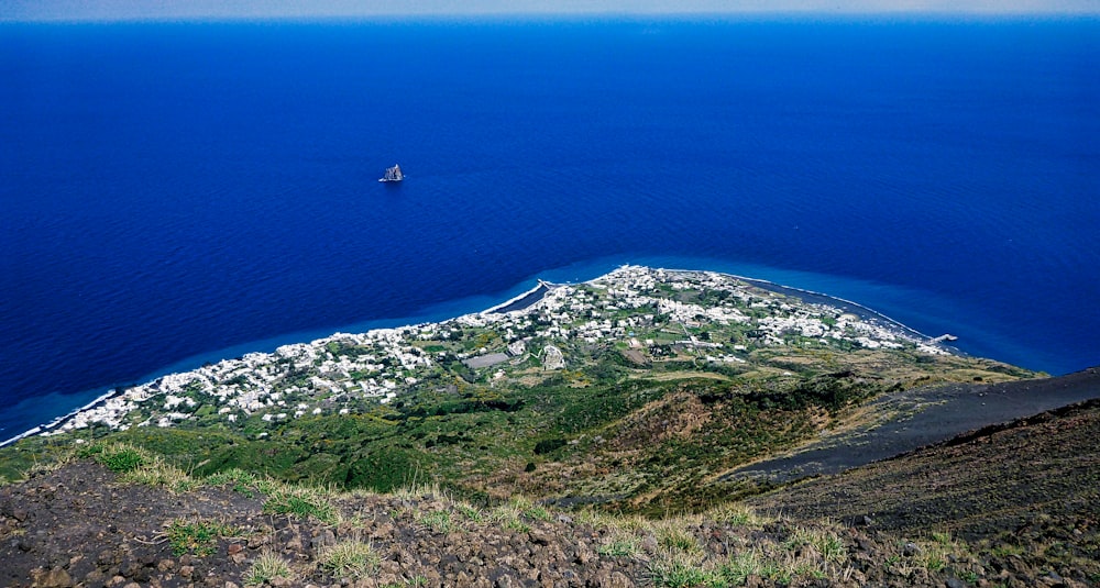 aerial view of green grass covered mountain near blue sea during daytime