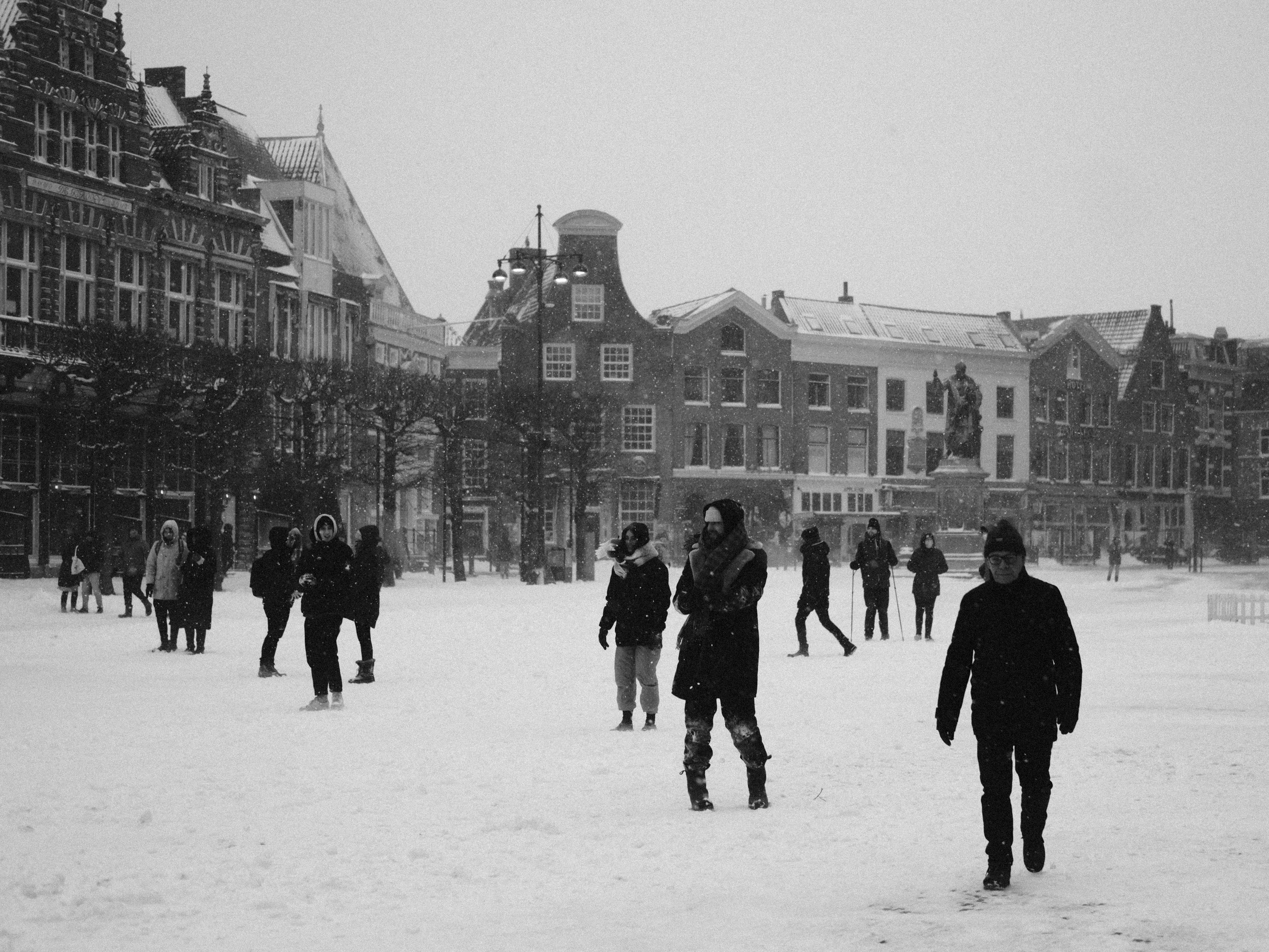 people walking on snow covered ground near building during daytime