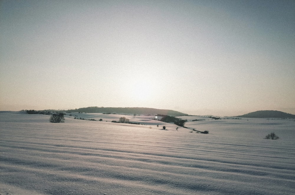 weißes und braunes Haus tagsüber auf schneebedecktem Feld