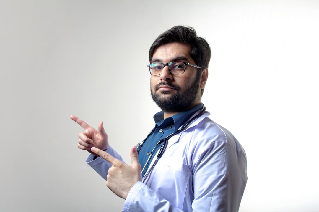man in white dress shirt wearing black framed eyeglasses, A doctor pointing sideways with neutral expressions