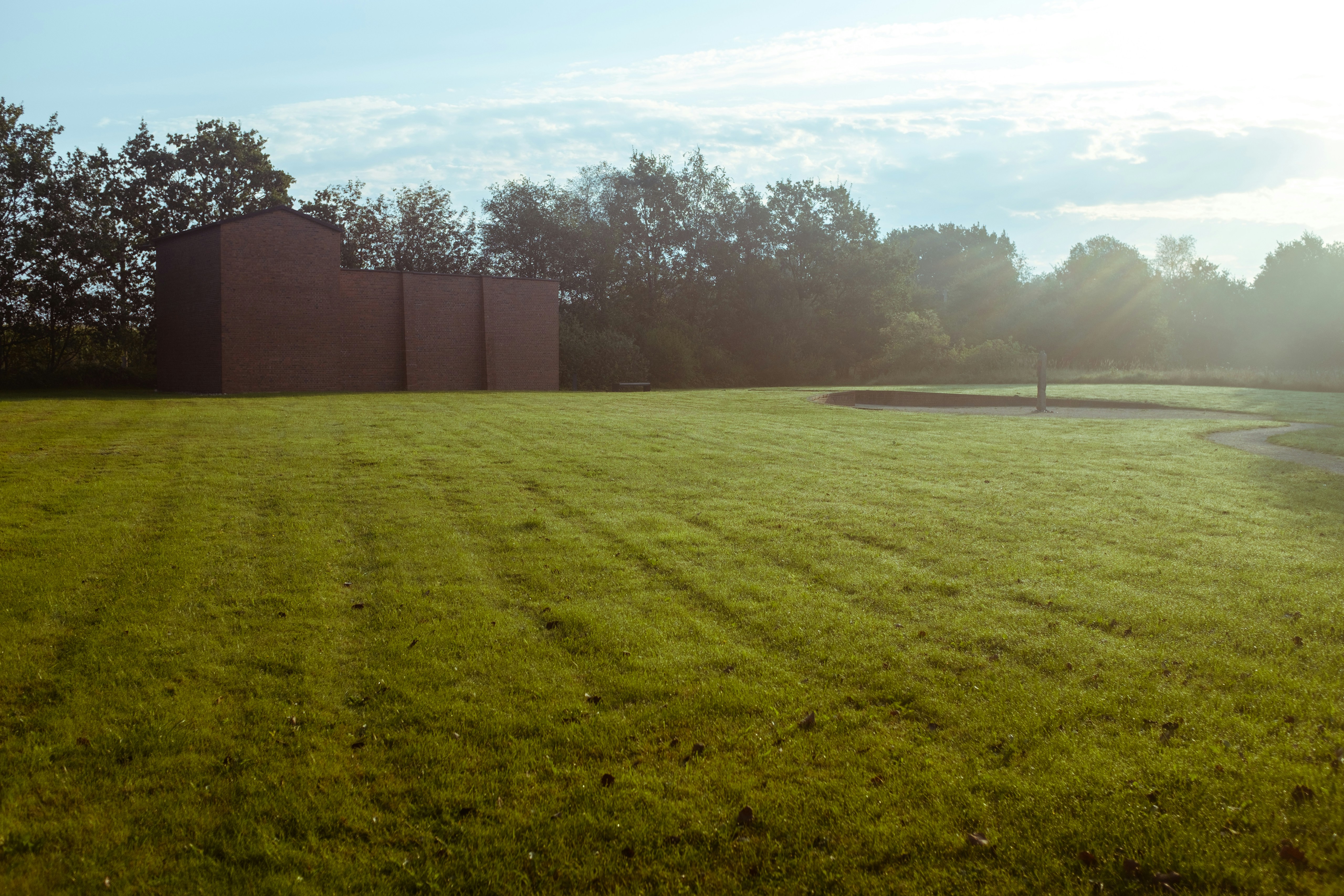 brown concrete building near green grass field during daytime, The memorial at the former concentration camp in Husum-Schwesing, Nordfriesland in the north of Germany.