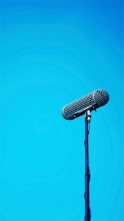 An audio technician adjusting a boom mic above a lively outdoor interview scene.