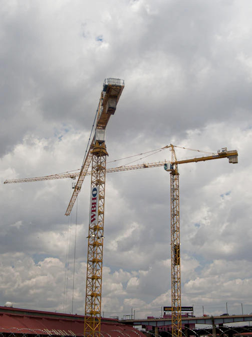yellow crane under cloudy sky during daytime