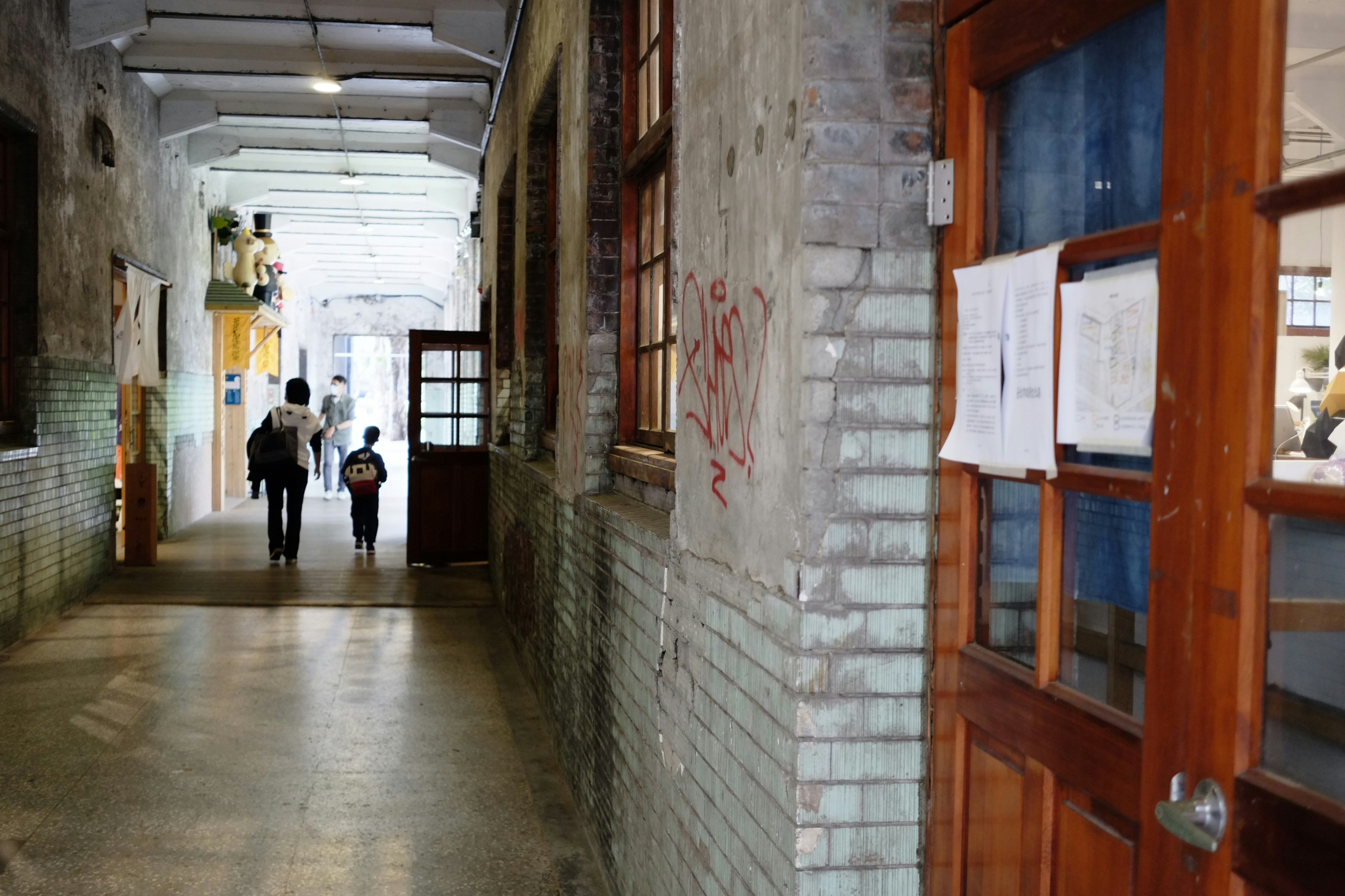 man in white shirt walking on hallway