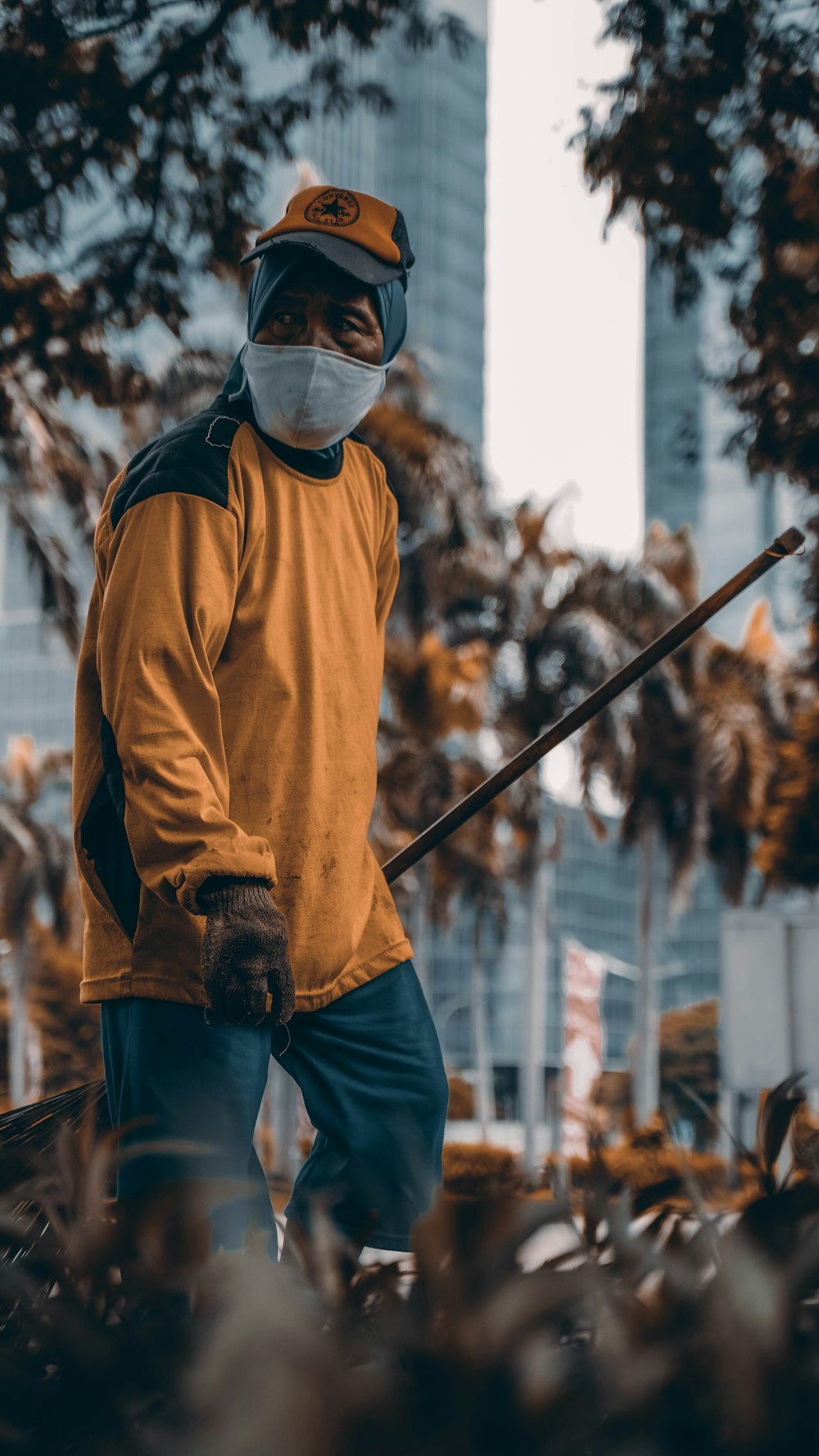 Hombre con suéter marrón y jeans de mezclilla azules con gafas negras