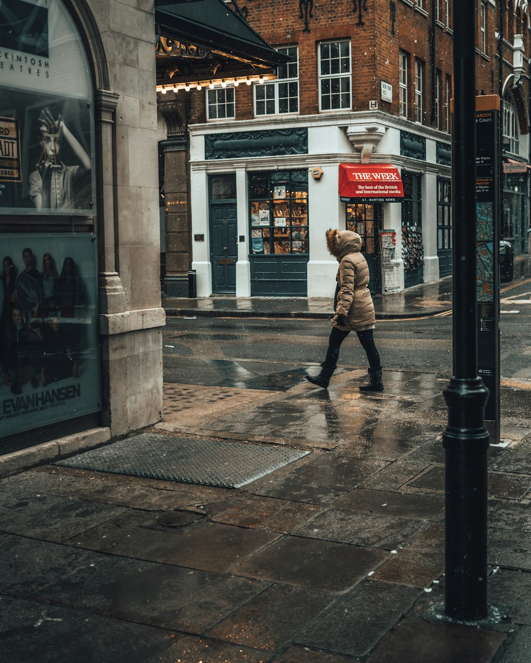 man in brown jacket walking on sidewalk during daytime