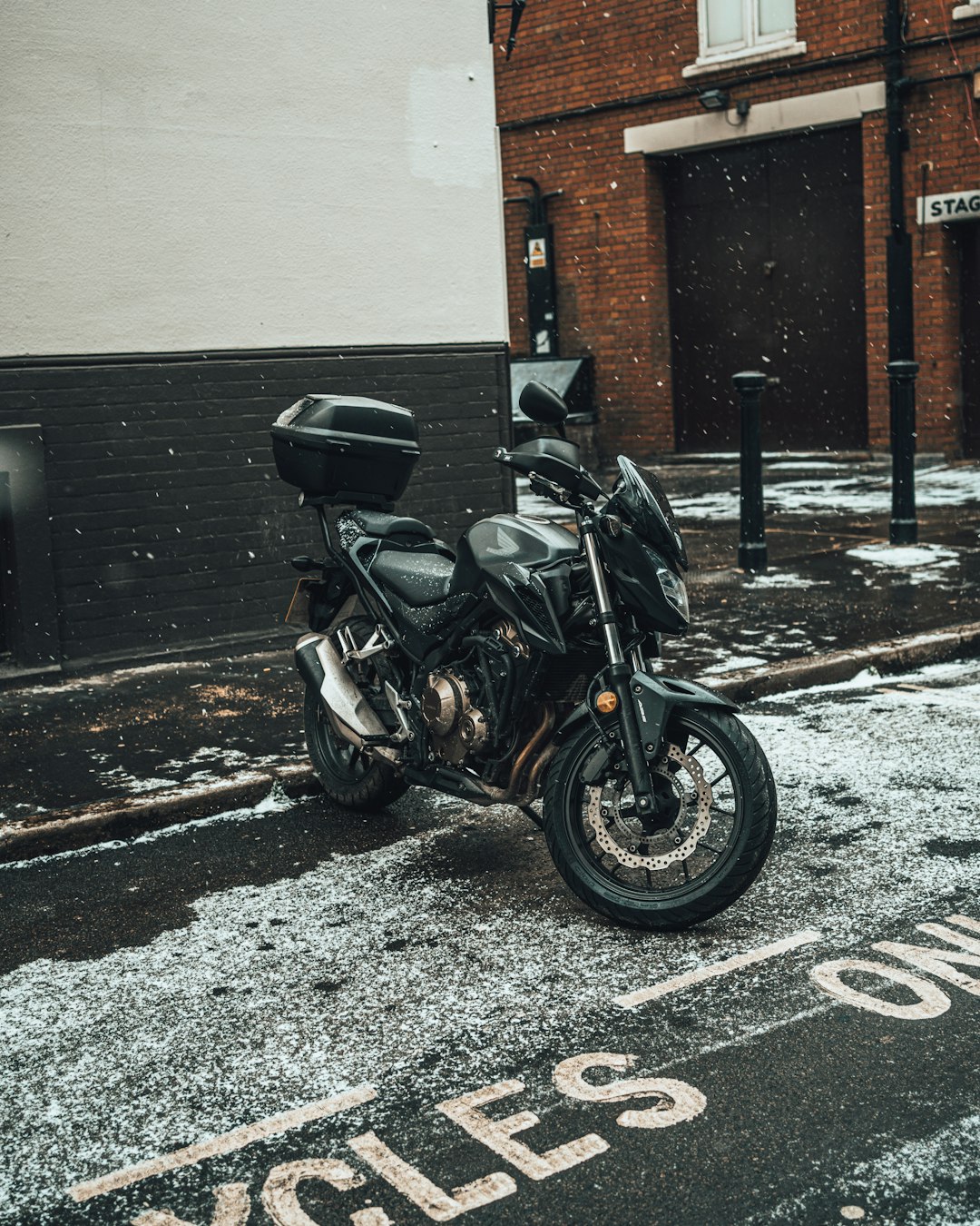 black motorcycle parked beside black metal fence during daytime