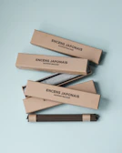 Elegant packaging boxes of 香韵百家 incense lined up on a minimalist shelf.