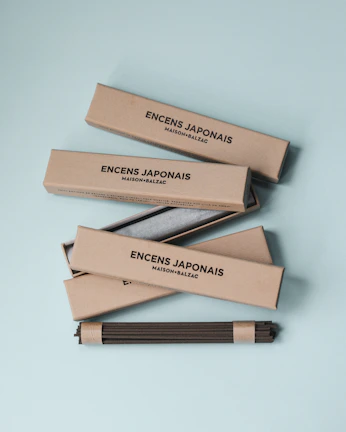 Elegant packaging of 香韵百家 incense products displayed on a minimalist shelf with warm tones