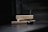 Two rectangular boxes labeled 'ENCENS JAPONAIS' rest horizontally, with a lit incense stick inserted into a black holder in the foreground. Smoke gently rises from the incense, creating a serene and tranquil atmosphere.