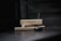 Two rectangular boxes labeled 'ENCENS JAPONAIS' rest horizontally, with a lit incense stick inserted into a black holder in the foreground. Smoke gently rises from the incense, creating a serene and tranquil atmosphere.