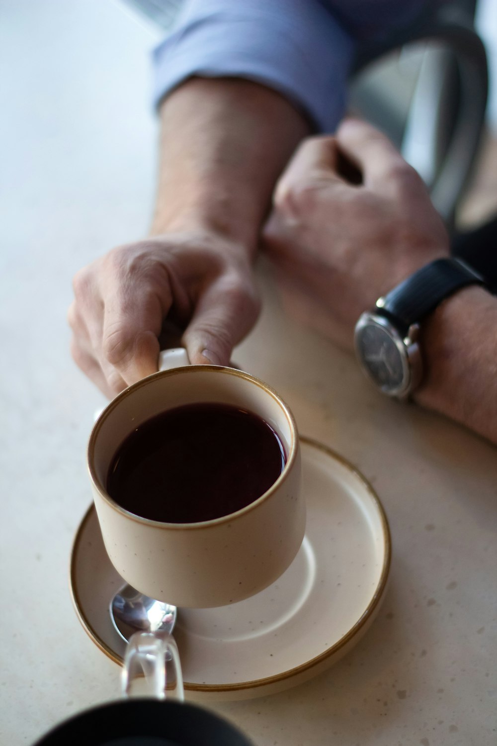 pessoa segurando caneca de cerâmica branca