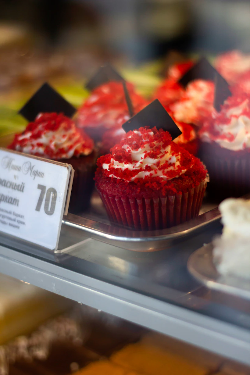 Pink and white cupcakes on a bakery display counter showing the need for custom bakery boxes
