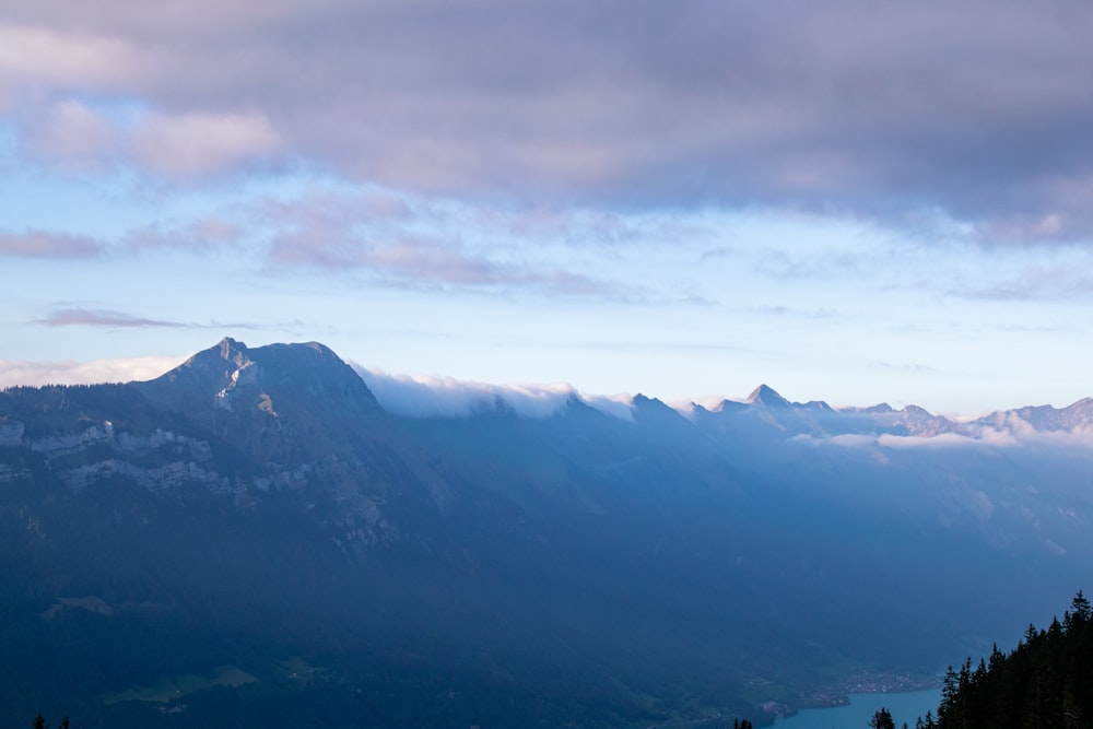 a scenic view of a mountain range with a lake in the foreground