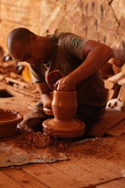 boy in gray and white stripe t-shirt making clay pot