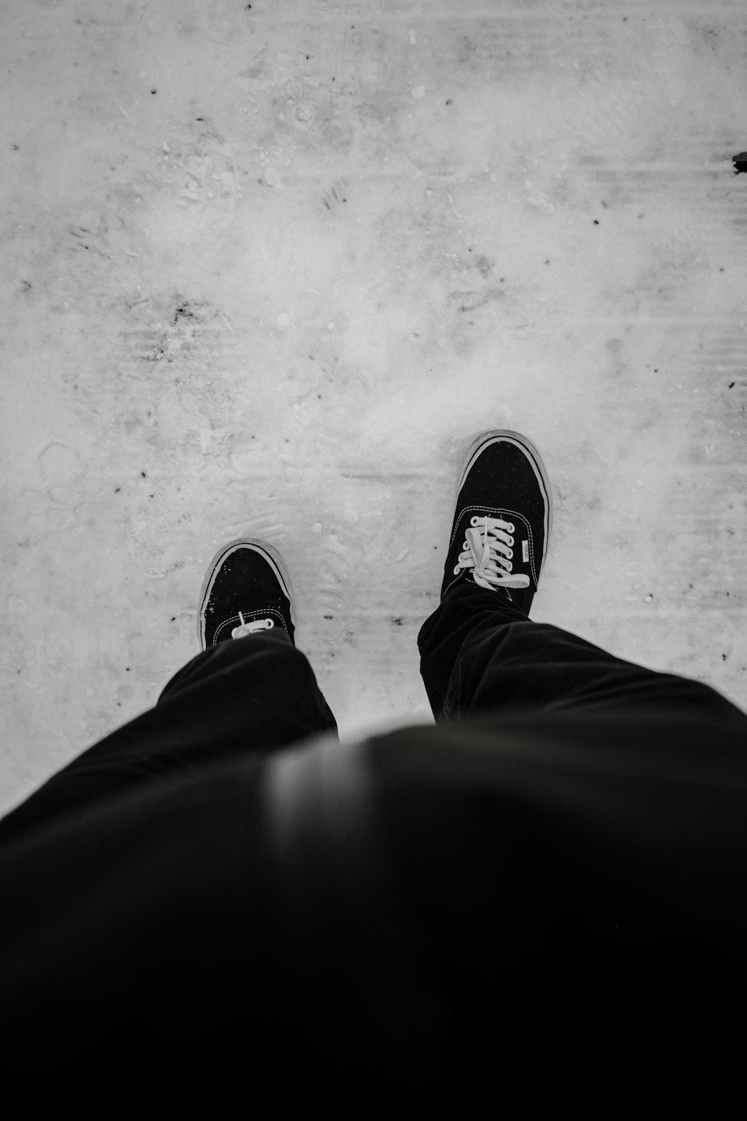 person in black pants and black and white sneakers