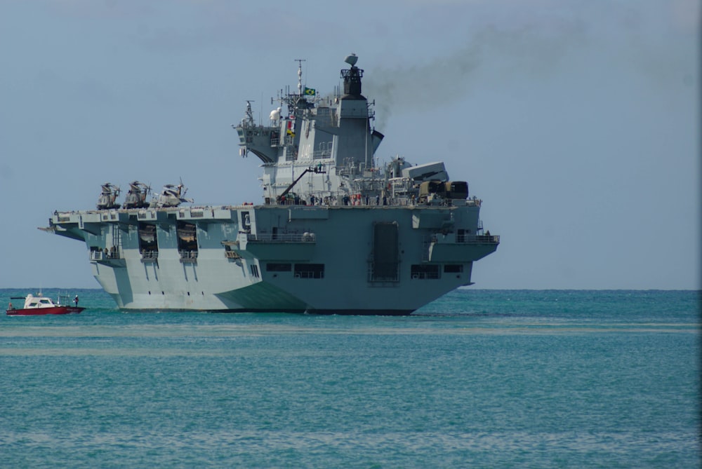 gray ship on sea under white clouds during daytime