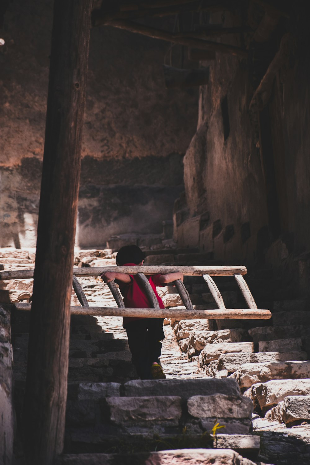 person in red shirt sitting on brown wooden bench