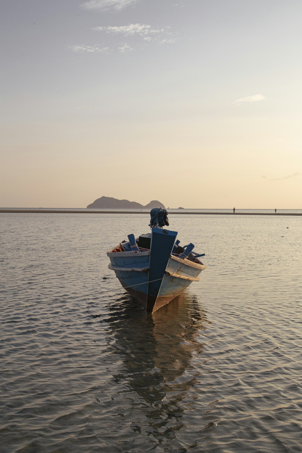 man in blue and white boat on sea during daytime