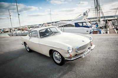 Instructor and pupil reviewing notes beside a parked car near Emsworth harbor.