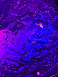 Abstract floating micro-shapes in neon purple and blue hues.