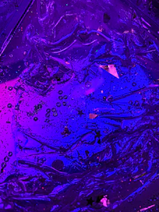 Abstract floating micro-shapes in neon purple and blue hues.