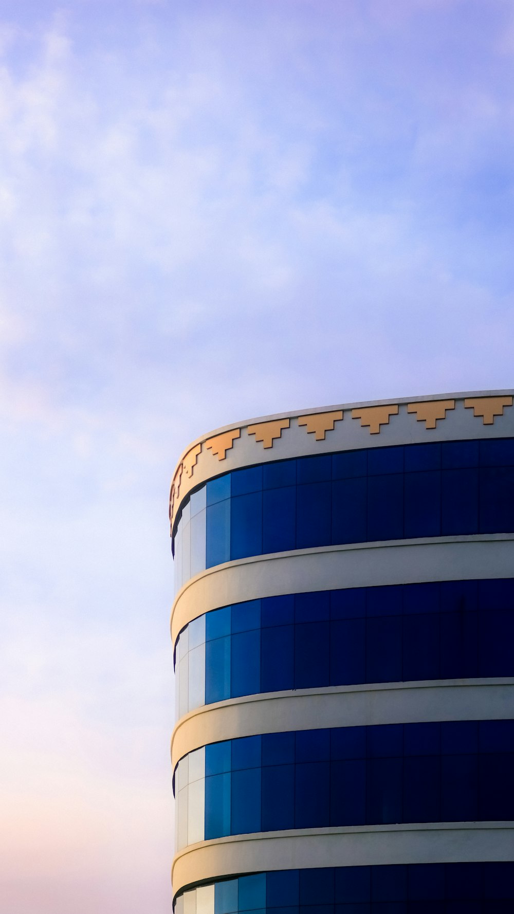 Edificio de hormigón azul y blanco bajo nubes blancas durante el día