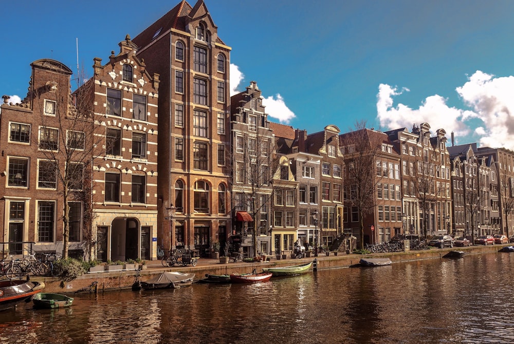 brown concrete building beside river during daytime