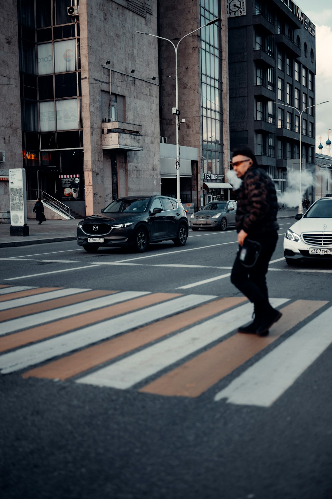 man in black jacket walking on pedestrian lane during daytime