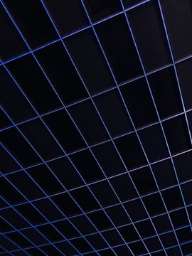 A grid of dark squares intersected by thin blue lines, creating a geometric pattern. The overall appearance suggests a structured and modern design.