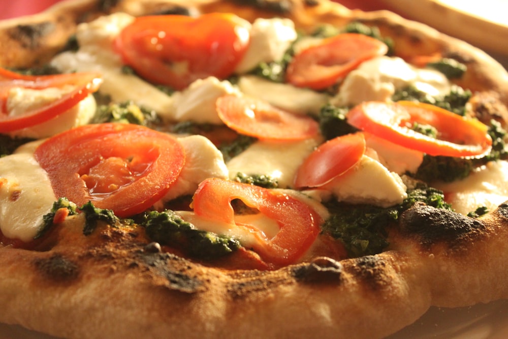 pizza with tomato and green leaf vegetable