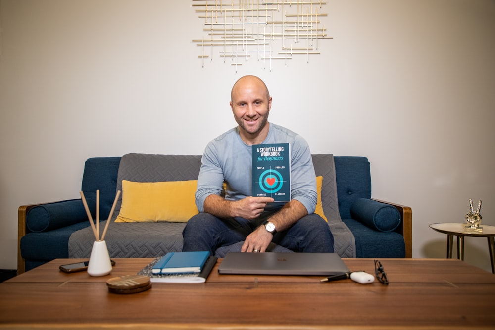 man in blue crew neck t-shirt sitting on blue sofa