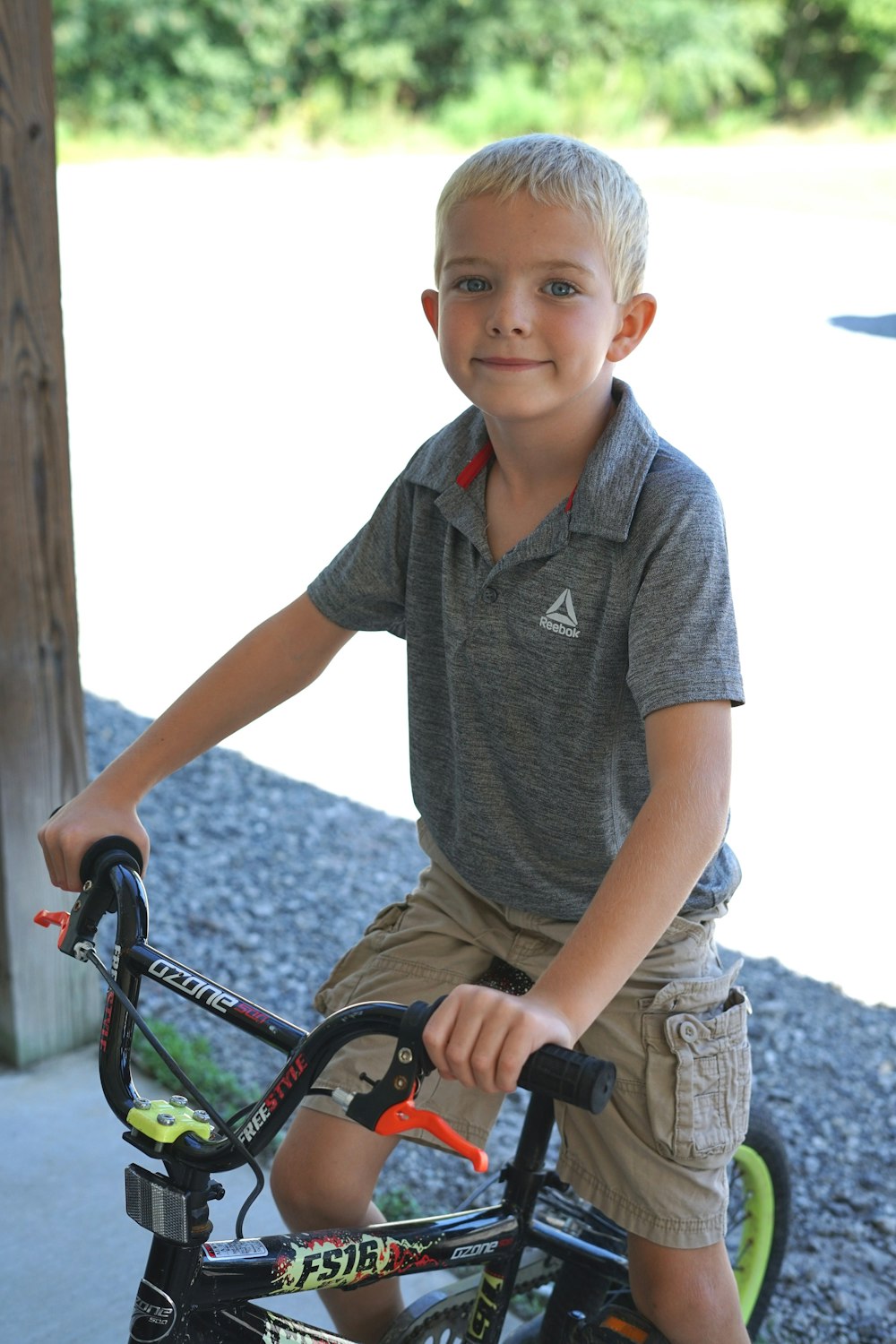 boy in grey polo shirt riding on bicycle