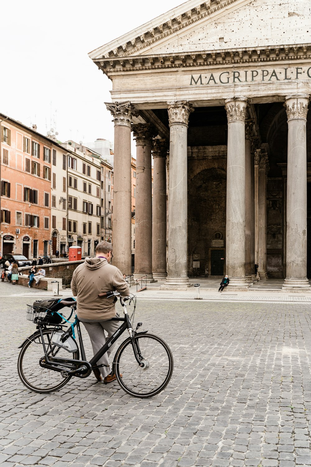 man in gray jacket riding bicycle on street during daytime