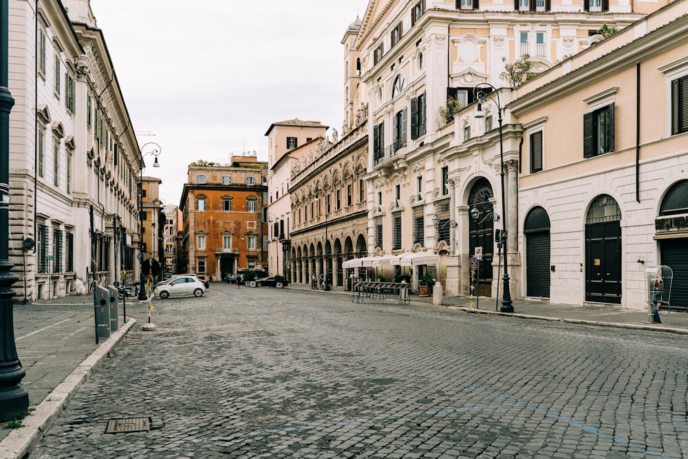 cars parked beside the road in between buildings during daytime